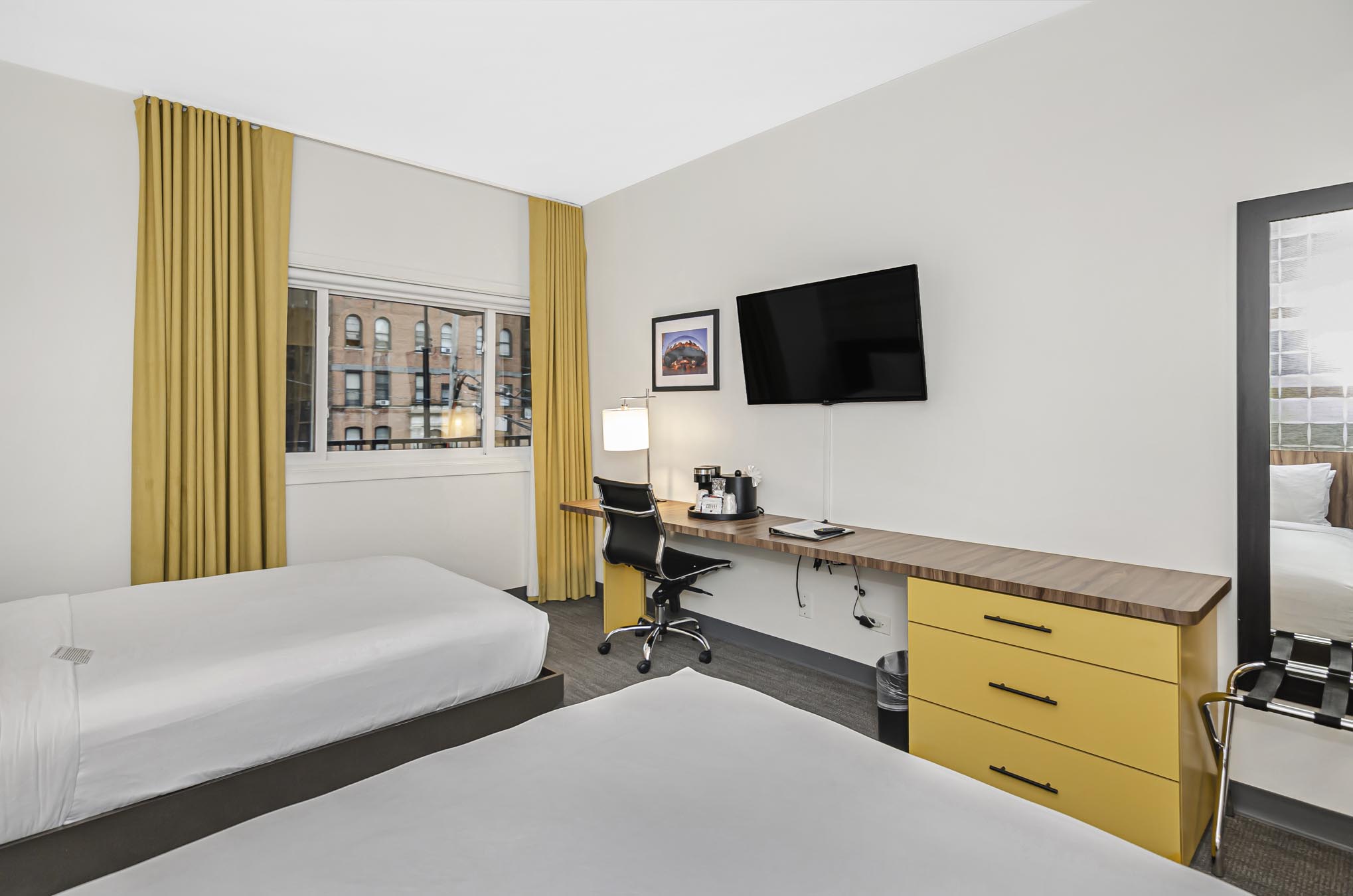 Two double beds, desk, swivel chair, and mounted TV