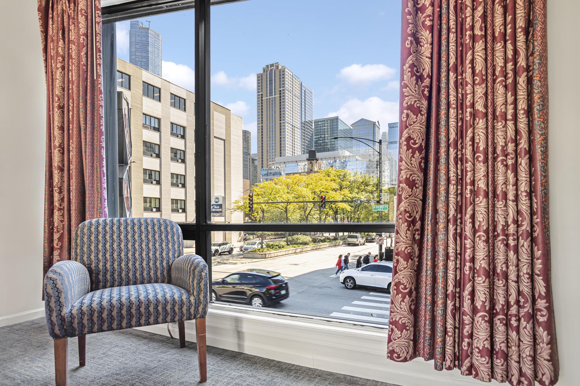 Grey chair beside window overlooking city