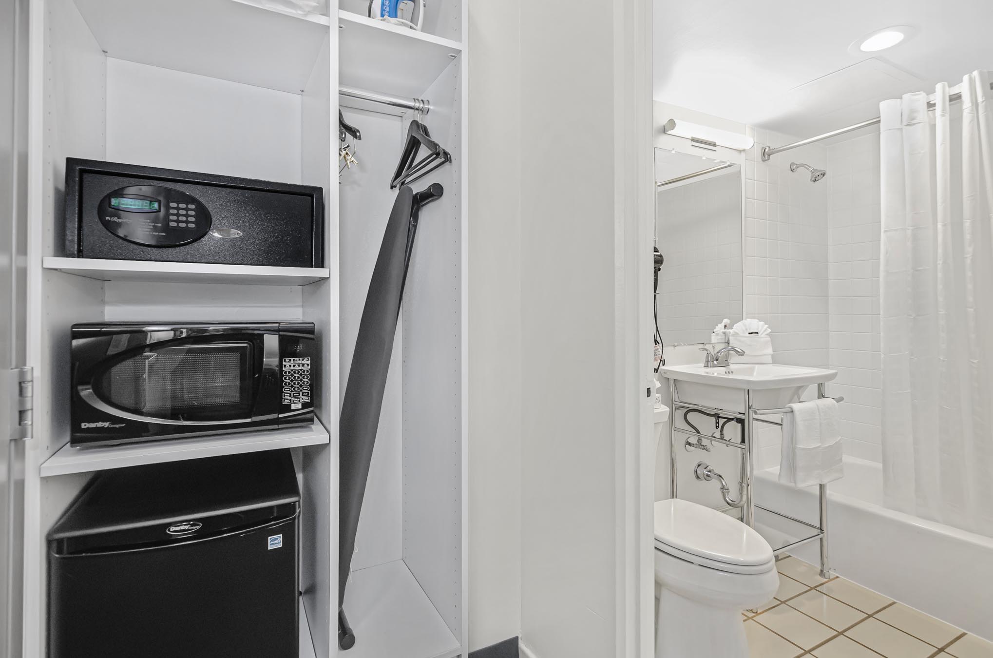 Safe, microwave, mini fridge, and closet beside bathroom