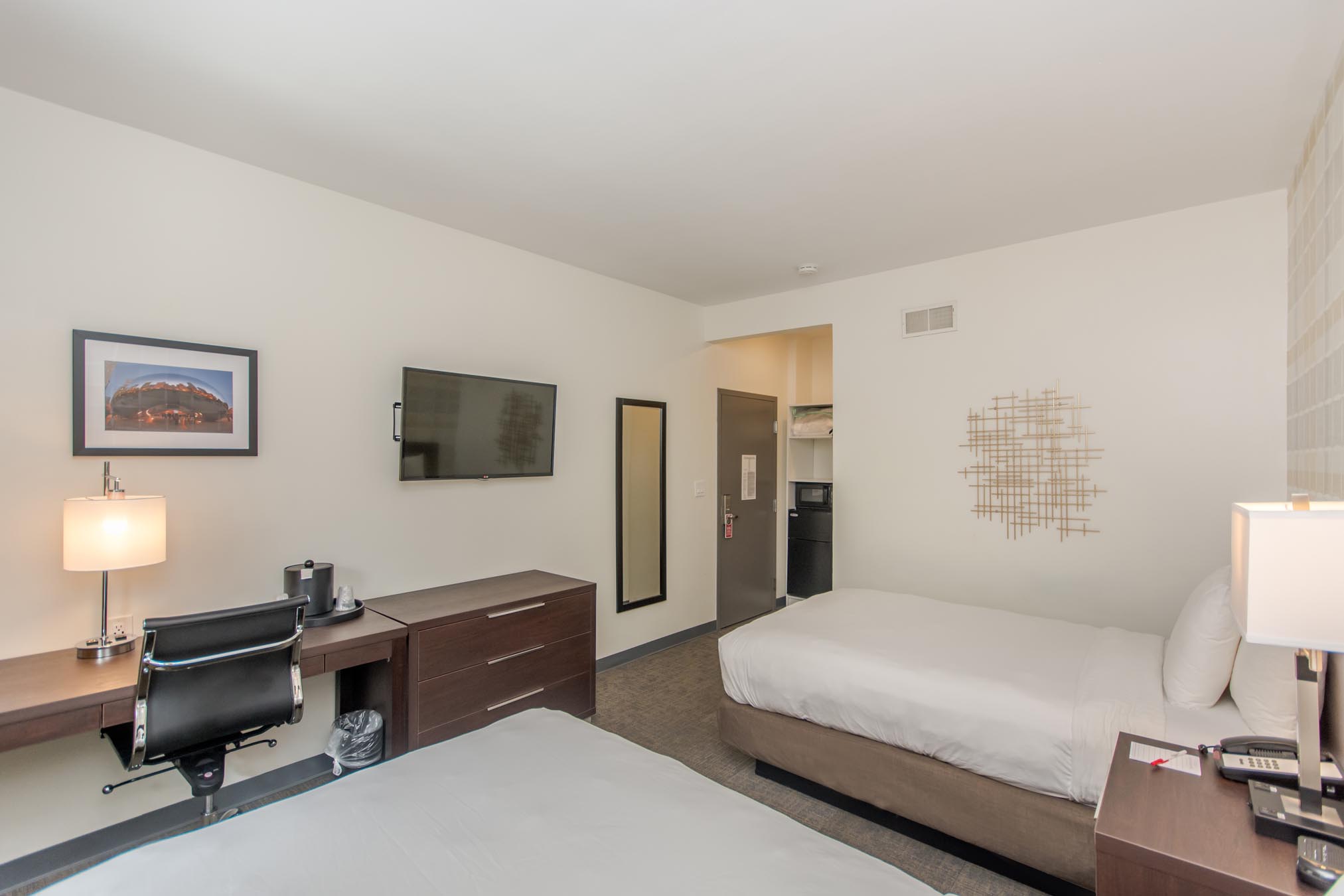 Desk with swivel chair beside two double beds